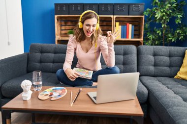 Genç, güzel bir kadın resim yapıyor. İnternetten öğretmenlik yapıyor. Parmaklarıyla imza atıyor. 