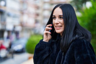 Young caucasian woman smiling confident talking on smartphone at street