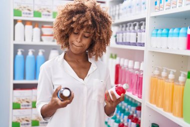 African american woman customer holding medication bottles at pharmacy