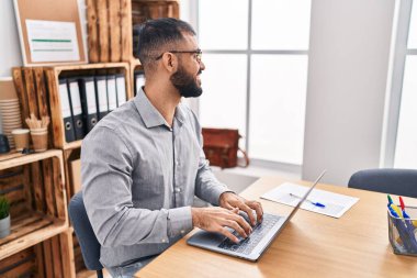 Young hispanic man business worker using laptop working at office
