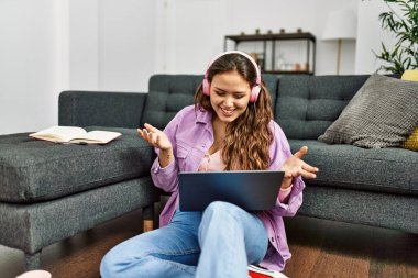 Genç, güzel, İspanyol bir kadın evde oturmuş video görüşmesi yapıyor.