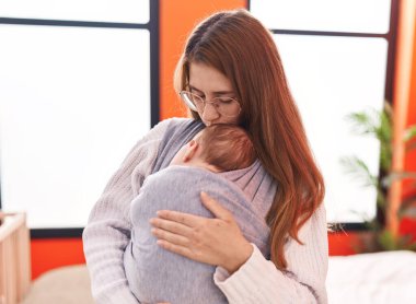 Anne ve oğul yatak odasında öpüşüp sarılıyorlar.