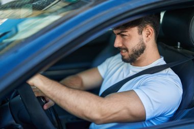Young hispanic man smiling confident driving car at street