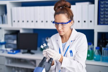 Young woman scientist holding samples working at laboratory