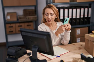 Young woman ecommerce busines worker using smartphone at office