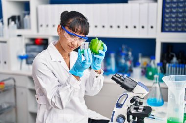 Laboratuvarda biber ölçme sıvısı tutan genç ve güzel İspanyol bilim kadını.