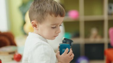 Adorable caucasian boy playing with cars at kindergarten
