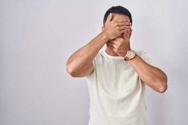 Sakallı İspanyol bir adam izole bir arka planda duruyor gözleri ve ağzı kapalı, şaşırmış ve şok olmuş bir halde. duygu gizleme 