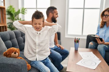 Family having psychology session son with hands on ears at psychology center