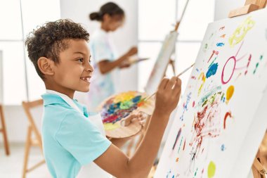 Erkek ve kız kardeş resim stüdyosunda güler yüzlü.