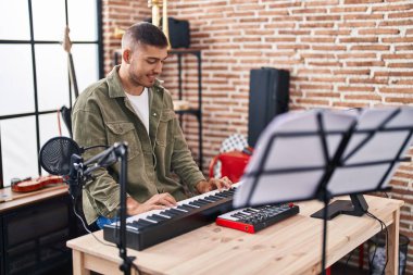 Genç İspanyol müzisyen müzik stüdyosunda piyano çalıyor.