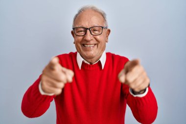 İzole edilmiş arka planda gri saçlı yaşlı adam parmaklarıyla seni ve kamerayı işaret ediyor, neşeli ve pozitif gülümsüyor. 