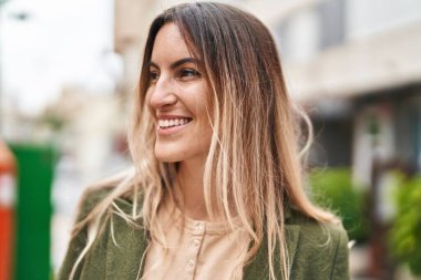 Young woman smiline confident looking to the side at street