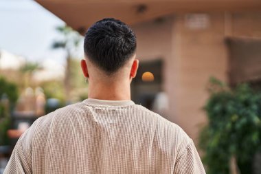Young arab man standing on back view at street