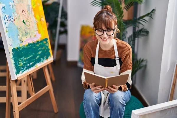Young Woman Artist Smiling Confident Reading Book Art Studio — Foto de Stock
