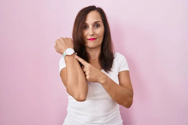 Middle Age Brunette Woman Standing Pink Background Hurry Pointing Watch — Photo