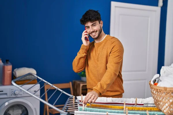 Genç Spanyol Adam Akıllı Telefondan Konuşuyor Çamaşırhanede Çamaşır Ipine Kıyafet — Stok fotoğraf