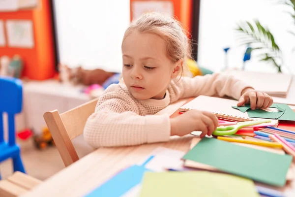 Adorable Blonde Girl Preschool Student Sitting Table Relaxed Expression Kindergarten — Stok fotoğraf