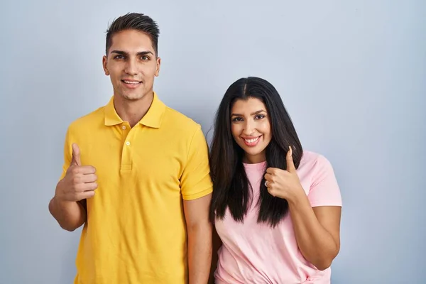 Young Couple Standing Isolated Background Doing Happy Thumbs Gesture Hand — 图库照片