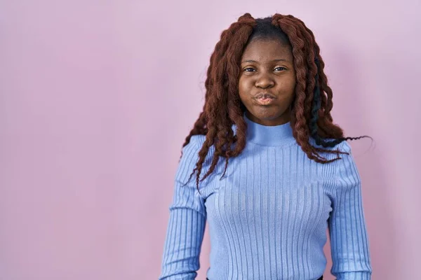 Afrikaanse Vrouw Staat Roze Achtergrond Puffende Wangen Met Grappig Gezicht — Stockfoto