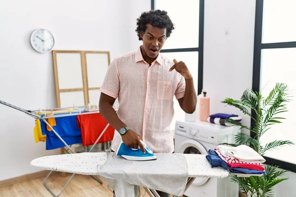 African Man Curly Hair Ironing Clothes Home Pointing Fingers Showing — Foto de Stock