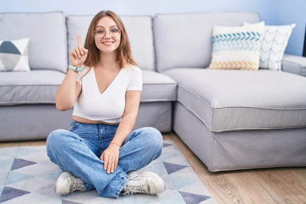Young Caucasian Woman Sitting Floor Living Room Showing Pointing Finger — Foto Stock
