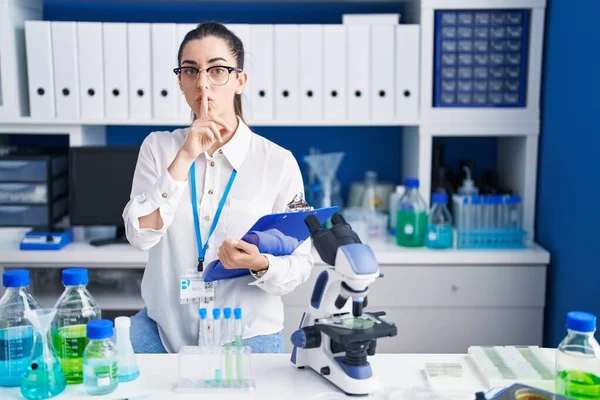 Young Brunette Woman Working Scientist Laboratory Asking Quiet Finger Lips — ストック写真