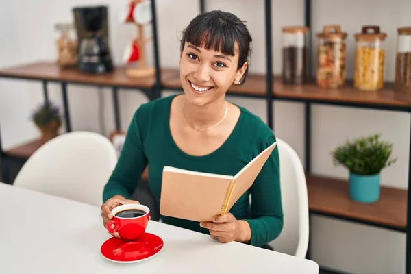 Young Beautiful Hispanic Woman Reading Book Drinking Coffee Sitting Table — Stock fotografie