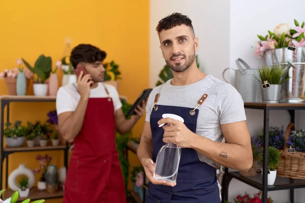 Two Hispanic Men Florists Holding Sprayer Talking Smartphone Flower Shop — Stock Photo, Image