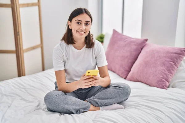Young Hispanic Woman Using Smartphone Sitting Bed Bedroom — Stock fotografie