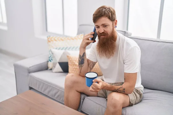 Young Redhead Man Talking Smartphone Sitting Sofa Home — Fotografia de Stock