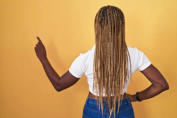 African American Woman Braided Hair Standing Yellow Background Posing Backwards — Zdjęcie stockowe