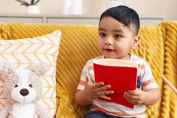 Adorable Niño Hispano Leyendo Libro Sentado Sofá Con Osito Peluche —  Fotos de Stock