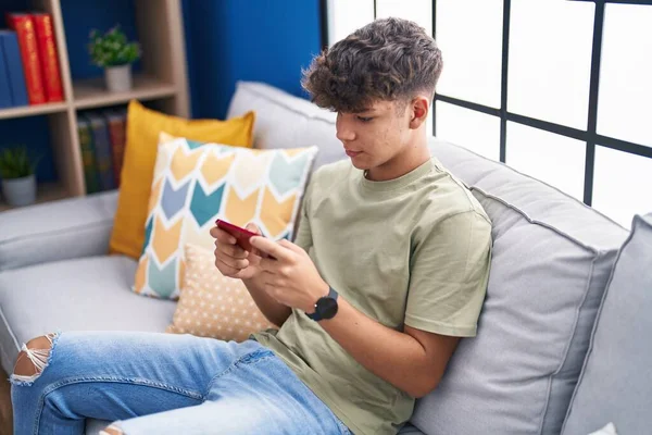 Young Hispanic Teenager Watching Video Smartphone Sitting Sofa Home — Stockfoto