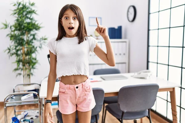 Young Hispanic Girl Standing Pediatrician Clinic Pointing Finger Successful Idea — Foto Stock