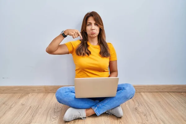 Hispanic Woman Using Laptop Sitting Floor Home Pointing Looking Sad —  Fotos de Stock