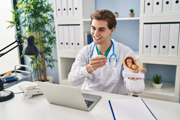 Young Caucasian Man Doctor Holding Anatomical Model Uterus Fetus Speaking — Zdjęcie stockowe