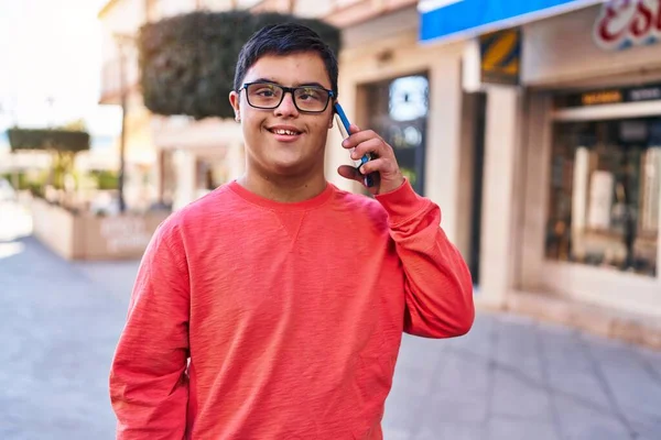 ダウン症候群の男は自信を持って話して笑顔路上でスマートフォン — ストック写真