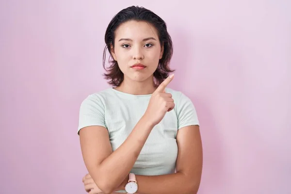 Hispanic Young Woman Standing Pink Background Pointing Hand Finger Side — ストック写真