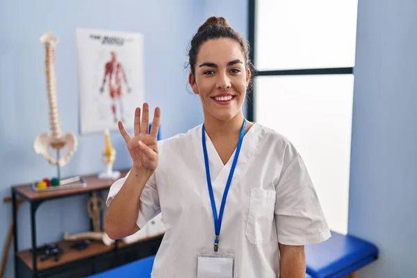 Young Hispanic Woman Working Rehabilitation Clinic Showing Pointing Fingers Number — ストック写真