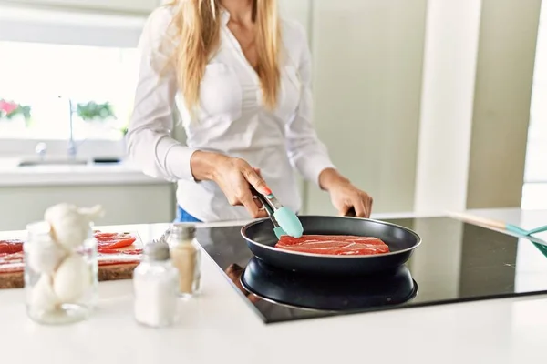 Genç Sarışın Kadın Mutfakta Biftek Pişiriyor — Stok fotoğraf