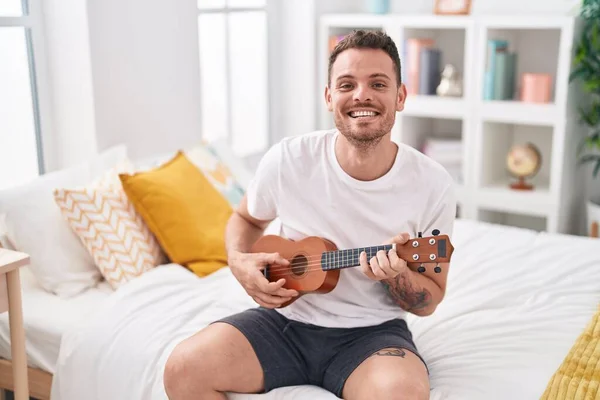 Ung Latinamerikansk Man Spelar Ukulele Sitter Sängen Sovrummet — Stockfoto