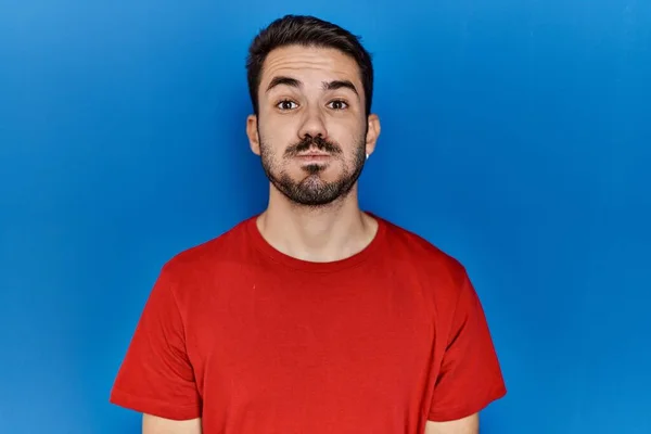 Young Hispanic Man Beard Wearing Red Shirt Blue Background Puffing — Stok fotoğraf