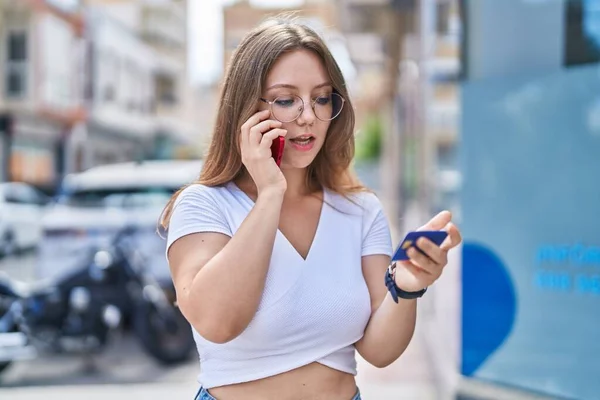 Young Blonde Woman Talking Smartphone Holding Card Street — Zdjęcie stockowe