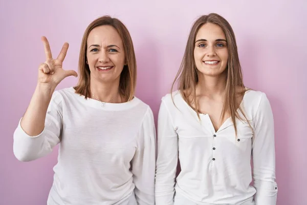 Middle Age Mother Young Daughter Standing Pink Background Showing Pointing — Stock Photo, Image