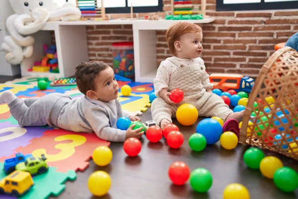 两个可爱的孩子在幼儿园的地板上玩球 — 图库照片