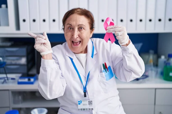 Ανώτερη Γυναίκα Γυαλιά Που Εργάζονται Εργαστήριο Επιστήμονας Κρατώντας Ροζ Κορδέλα — Φωτογραφία Αρχείου