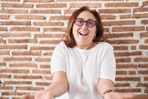 Senior Woman Glasses Standing Bricks Wall Smiling Cheerful Offering Hands — Fotografia de Stock