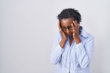 African woman with dreadlocks standing over white background wearing glasses with sad expression covering face with hands while crying. depression concept. 