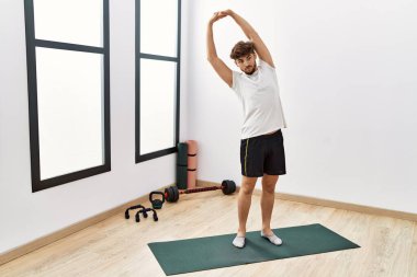 Young arab man stretching at sport center